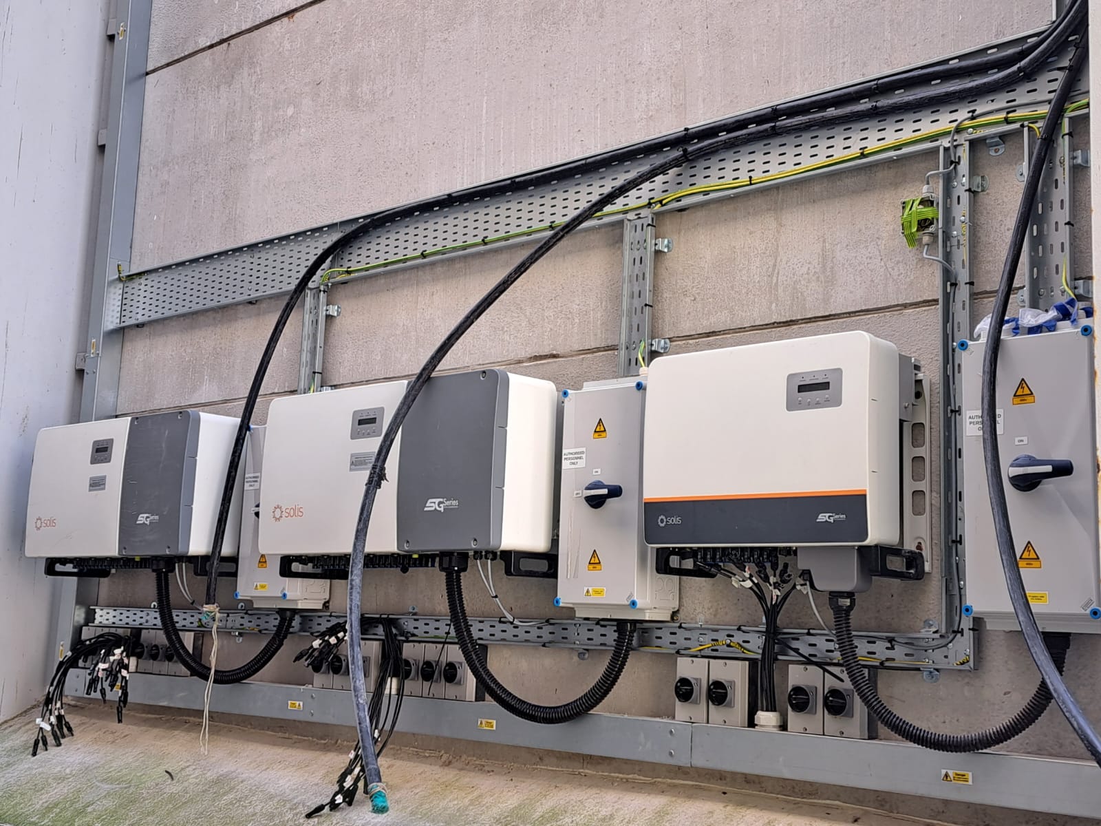 solar inverters installed in a solar photovoltaic (PV) system, converting the DC electricity from solar panels into AC electricity for commercial use